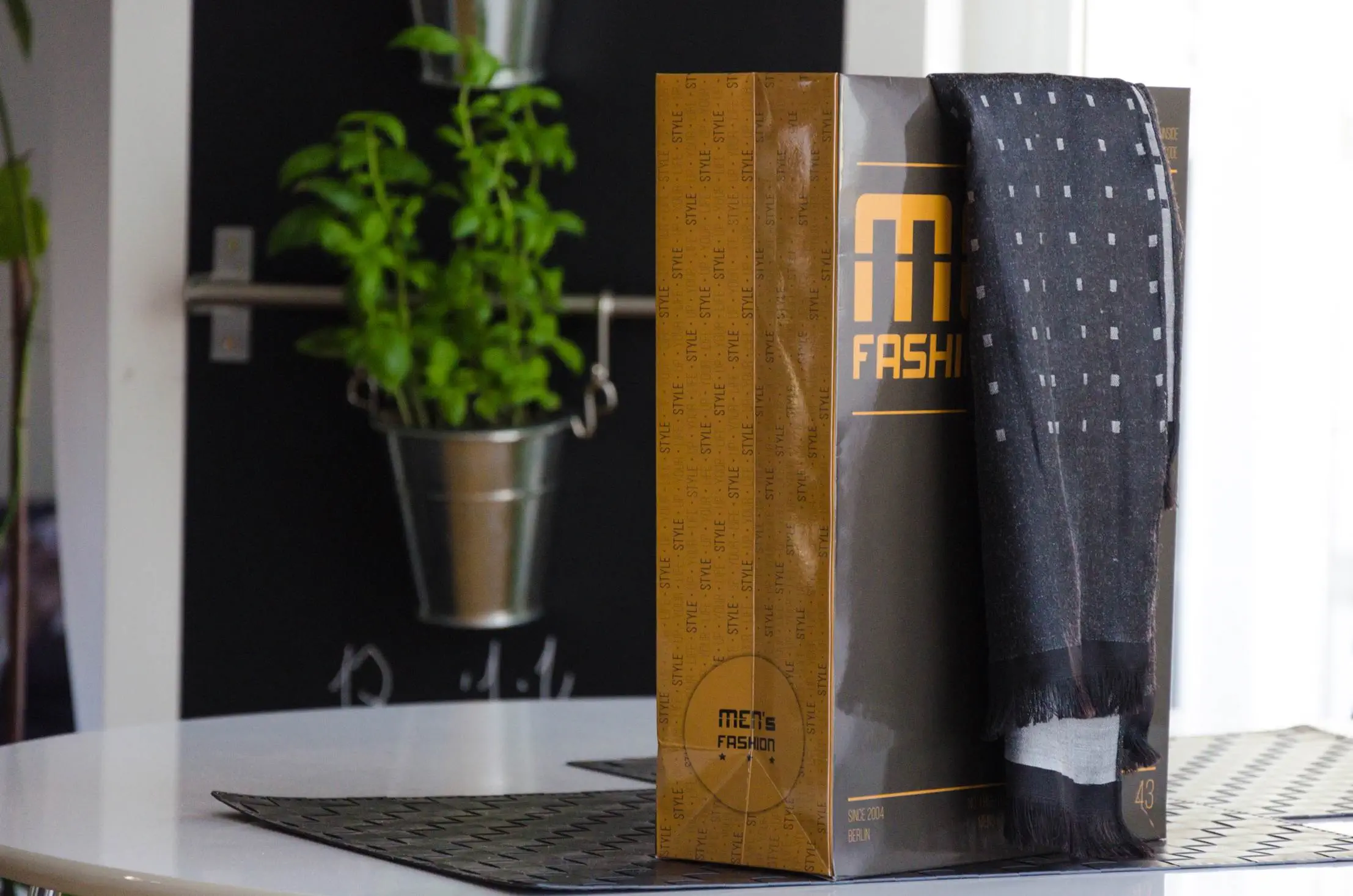 Schwarze orange Papiertragetasche auf weißen Tisch 