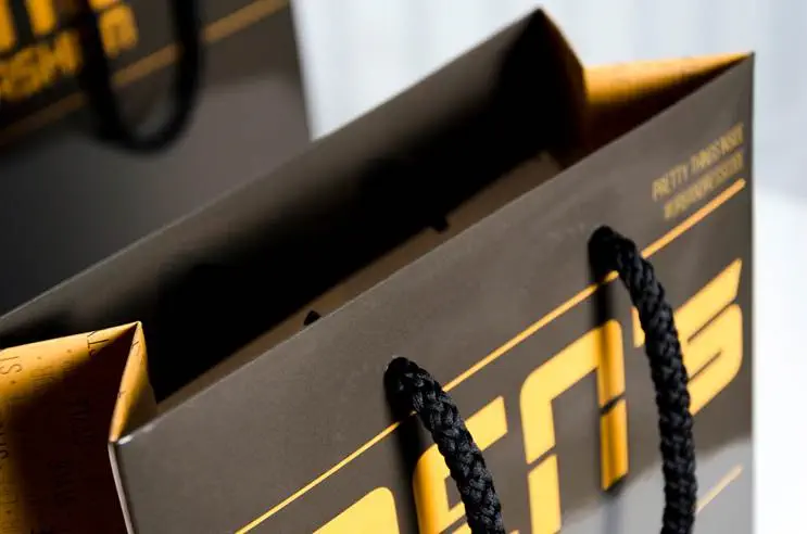 Schwarze orange Papiertragetasche auf weißen Hintergrund