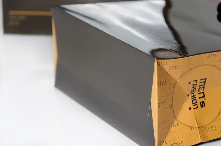 Schwarze orange Papiertragetasche auf weißen Hintergrund